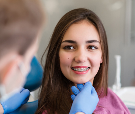 a patient with braces smiling during an appointment